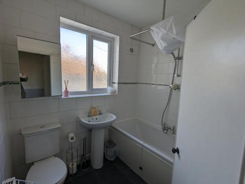 y baño con aseo, lavabo y bañera. en 5 bed terraced family home Bristol + parking, en Bristol