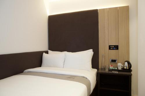 a bed with white sheets and a black head board at The Z Hotel Shoreditch in London