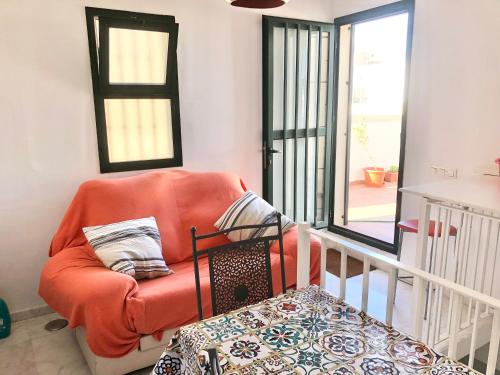 an orange chair in a room with a balcony at Maravilloso alojamiento en pleno centro de Dos Hermanas in Dos Hermanas