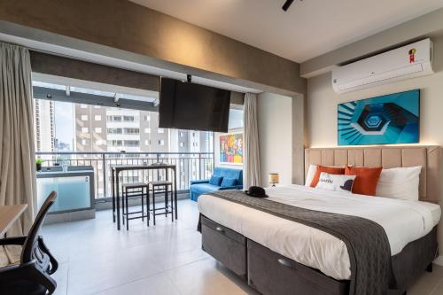 a bedroom with a large bed and a balcony at Charlie Vitrali Moema in Sao Paulo