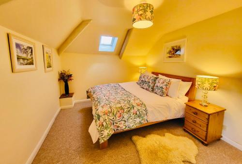 a bedroom with a bed and a night stand with a lamp at Barn End Cottage in High Bickington