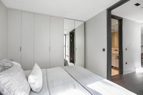 sypialnia z białymi ścianami i dużym lustrem w obiekcie New Build-Air Con-2 Bedroom-Two Bathrooms Apt 6 w Londynie
