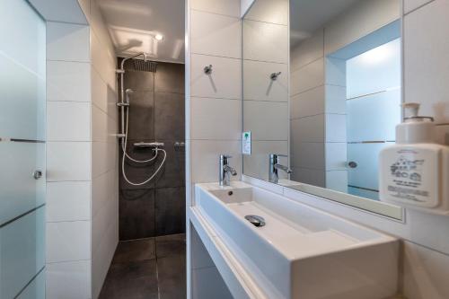 a white bathroom with a sink and a shower at AKZENT Hotel Restaurant Roter Ochse Rhens bei Koblenz in Rhens