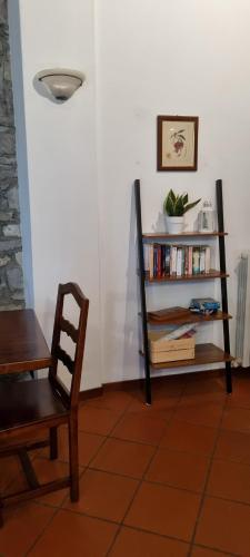 ein Zimmer mit einem Stuhl und einem Bücherregal mit Büchern in der Unterkunft La Casetta di Sornico in Lierna