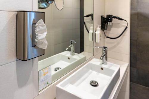 a bathroom with a sink and a mirror at AKZENT Hotel Restaurant Roter Ochse Rhens bei Koblenz in Rhens