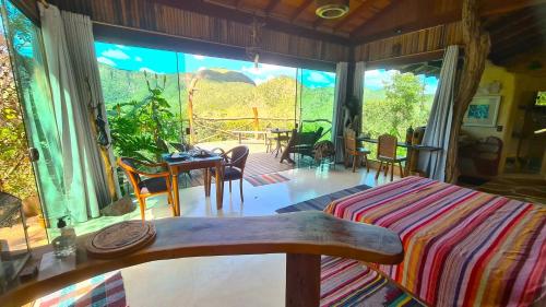 a living room with a bed and a large window at Ecopousada Toca do Guará in Alto Paraíso de Goiás