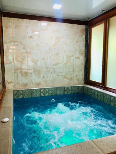 una gran bañera de hidromasaje en una habitación en Munay Wasi by Hospedaje Puntzán en Baños