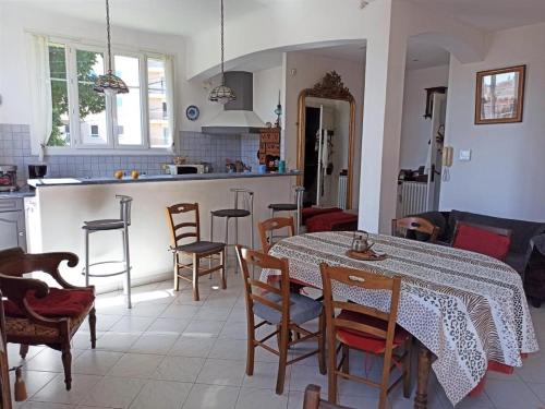 a kitchen and living room with a table and chairs at Villa tres proche du centre ville in Nice