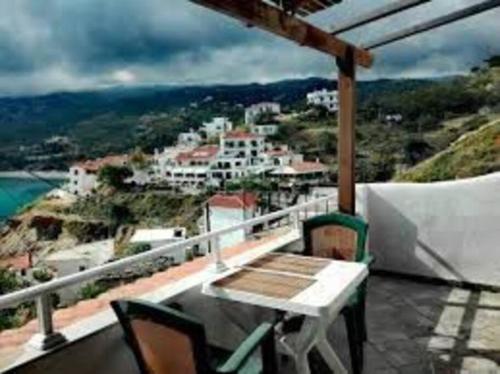 a balcony with a table and chairs and a view at Δίχωρο στούντιο στον κέντρο του Αρμενιστή in Armenistis