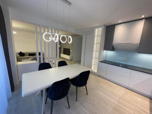 a kitchen with a white table and some chairs at Gega Apartments in Gjakove