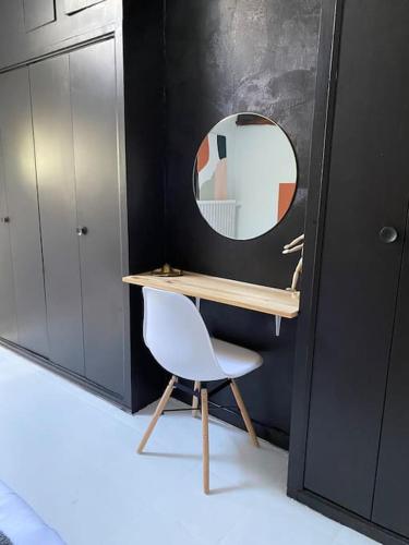 a desk with a chair and a mirror in a room at L'euphoria - Cœur historique Saumur - Château in Saumur