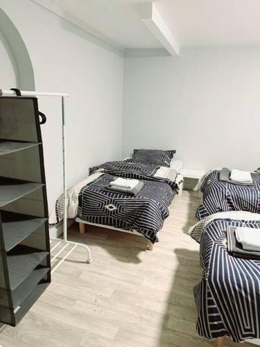 um quarto com três camas e uma cómoda em Porte la chapelle appartement 4 personnes "Appart'5" em Pierrefitte-sur-Seine