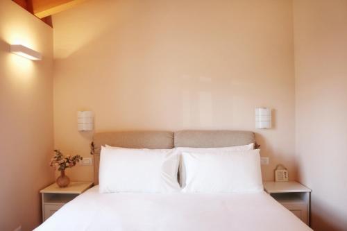 a bedroom with a bed with white sheets and pillows at Civico Sei in Menaggio