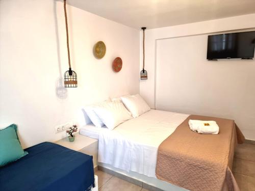 a small bedroom with a bed and a tv at Joannes Vacation Rooms in Adamas