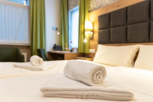 two towels on a bed in a hotel room at AKZENT Hotel Restaurant Roter Ochse Rhens bei Koblenz in Rhens