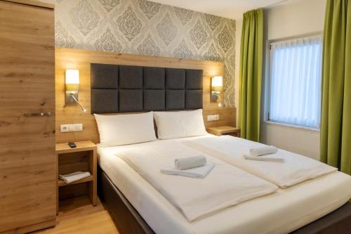 a bedroom with a large bed with two towels on it at AKZENT Hotel Restaurant Roter Ochse Rhens bei Koblenz in Rhens
