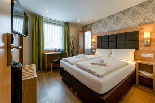 a bedroom with a large bed in a room at AKZENT Hotel Restaurant Roter Ochse Rhens bei Koblenz in Rhens