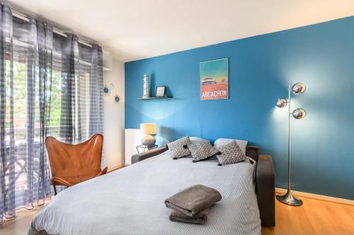アルカションにあるLa dune blanche d'Arcachonの青いベッドルーム(ベッド1台、椅子付)
