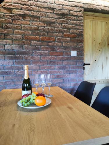 a bottle of wine and a plate of fruit on a table at Na Zaciszu in Cierzpięty