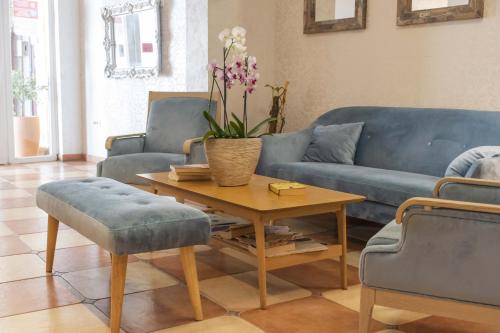 sala de estar con sofá azul y mesa en Mali Hotel Porat, en Budva