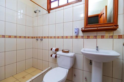 a bathroom with a toilet and a sink at Hotel Villa Laguna in Puerto Ayora