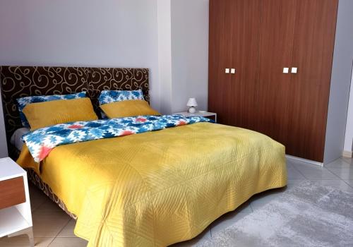 a bedroom with a bed with a yellow comforter at Sunshine Apartments in Golem