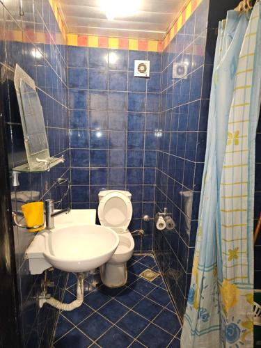 a blue tiled bathroom with a toilet and a sink at Porto Marina pool and sea view apartment in El Alamein