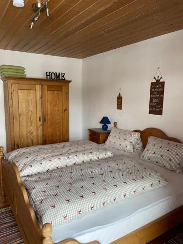 1 dormitorio con 1 cama con un cartel en la pared en Freudenmacher, en Sankt Ulrich am Pillersee