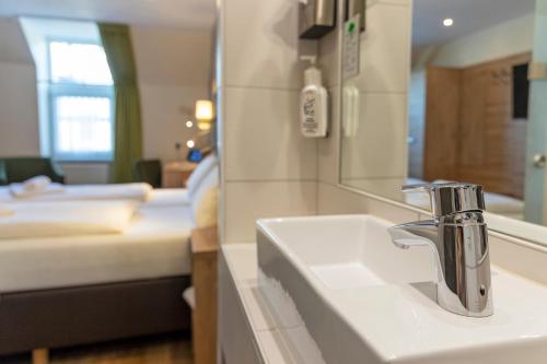 a bathroom with a sink and a mirror at AKZENT Hotel Restaurant Roter Ochse Rhens bei Koblenz in Rhens