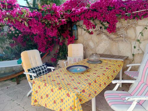 - une table avec des chaises et des fleurs sur la terrasse dans l'établissement White villa few steps from most amazing beaches in Denia, swimming pool,parking, à Dénia