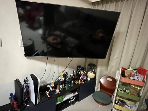 a flat screen tv hanging on a wall with action figures at MingHOW'S House 清水海線溫馨客房有雙人床位、電視、冷氣、獨立衣櫃 in Erh-t'ang-lang