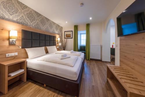a hotel room with a large bed and a television at AKZENT Hotel Restaurant Roter Ochse Rhens bei Koblenz in Rhens