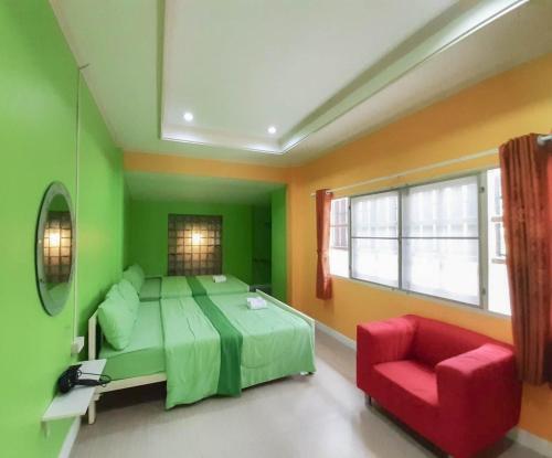 a green bedroom with a bed and a red chair at The Peak Pool villa, Huahin in Hua Hin