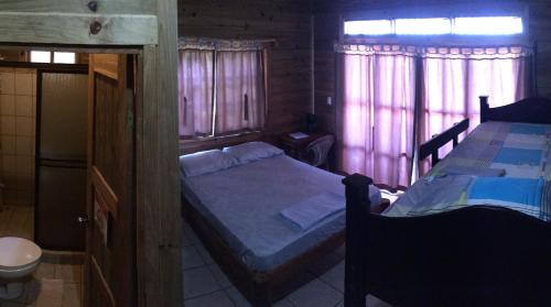 a bedroom with two beds and two windows at Blue Dream Kite Boarding Resort Costa Rica in Puerto Soley