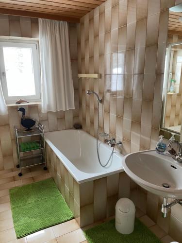 ein Badezimmer mit einer Badewanne und einem Waschbecken in der Unterkunft Freudenmacher in Sankt Ulrich am Pillersee