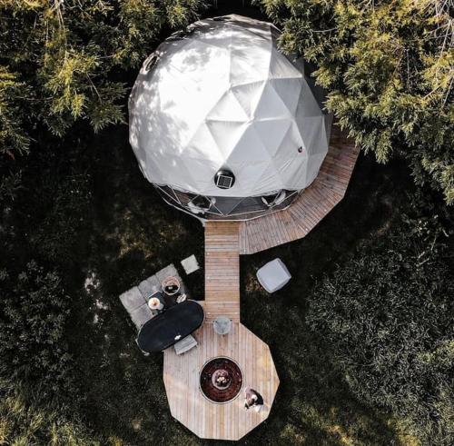 an overhead view of a circular building on a wooden deck at Beautiful Olive Pod Geo Dome House with Hot Tub in East Horsley