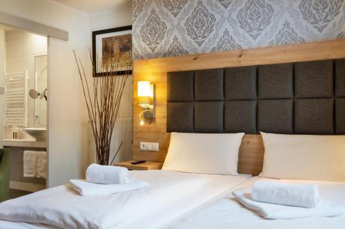 a bedroom with a bed with two towels on it at AKZENT Hotel Restaurant Roter Ochse Rhens bei Koblenz in Rhens
