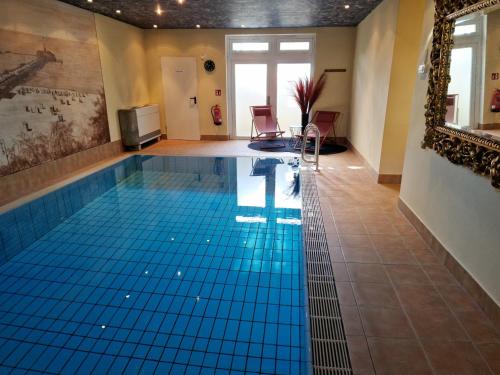 een zwembad met een blauwe tegelvloer in een kamer bij Villa Bleichröder in Heringsdorf