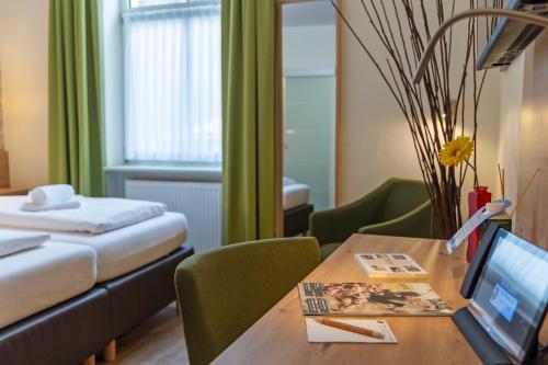 a hotel room with a bed and a table with a laptop at AKZENT Hotel Restaurant Roter Ochse Rhens bei Koblenz in Rhens