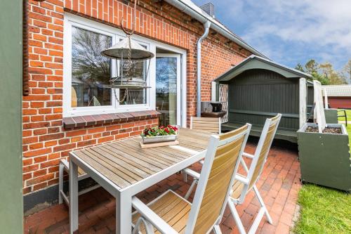 a wooden table and chairs outside a brick house at Meerfamilie in Noer