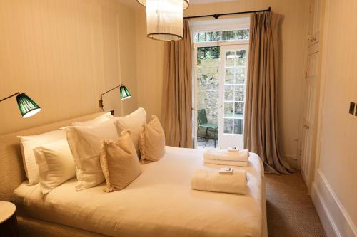 a large white bed in a room with a window at Brand new Georgian flat in Bath in Bath