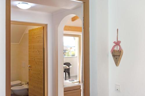 uma casa de banho com um espelho e um WC num quarto em Stiflerhof Apt Alpenrose em Falzes