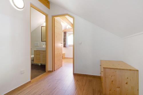 a white room with a wooden table and a mirror at Stiflerhof Apt Alpenrose in Falzes