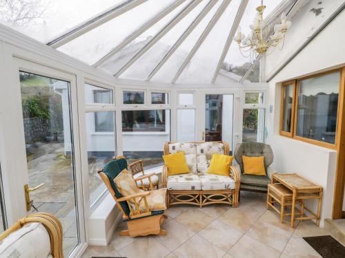a conservatory with chairs and a chandelier at Saoirse in Gortmore