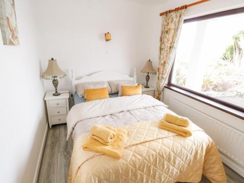 two beds in a bedroom with a window at Saoirse in Gortmore