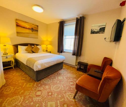 um quarto de hotel com uma cama e uma cadeira em Fairlight Guesthouse em Glenridding