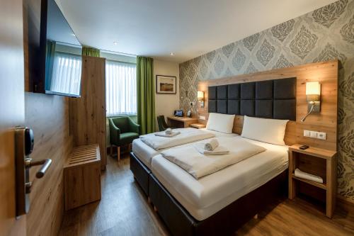 a hotel room with a large bed and a television at AKZENT Hotel Restaurant Roter Ochse Rhens bei Koblenz in Rhens
