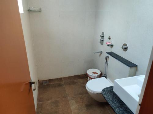 Achates Corporate Services في بانغالور: حمام به مرحاض أبيض ومغسلة