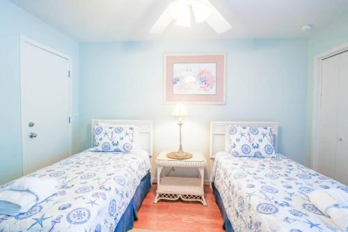 two beds in a room with blue walls at Rue De Buci in Johns Island