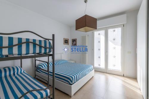 um quarto com 2 beliches e uma janela em Condominio Stella em Lido di Jesolo